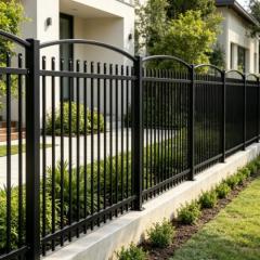 Black aluminum privacy fence panel with vertical pickets installed in backyard